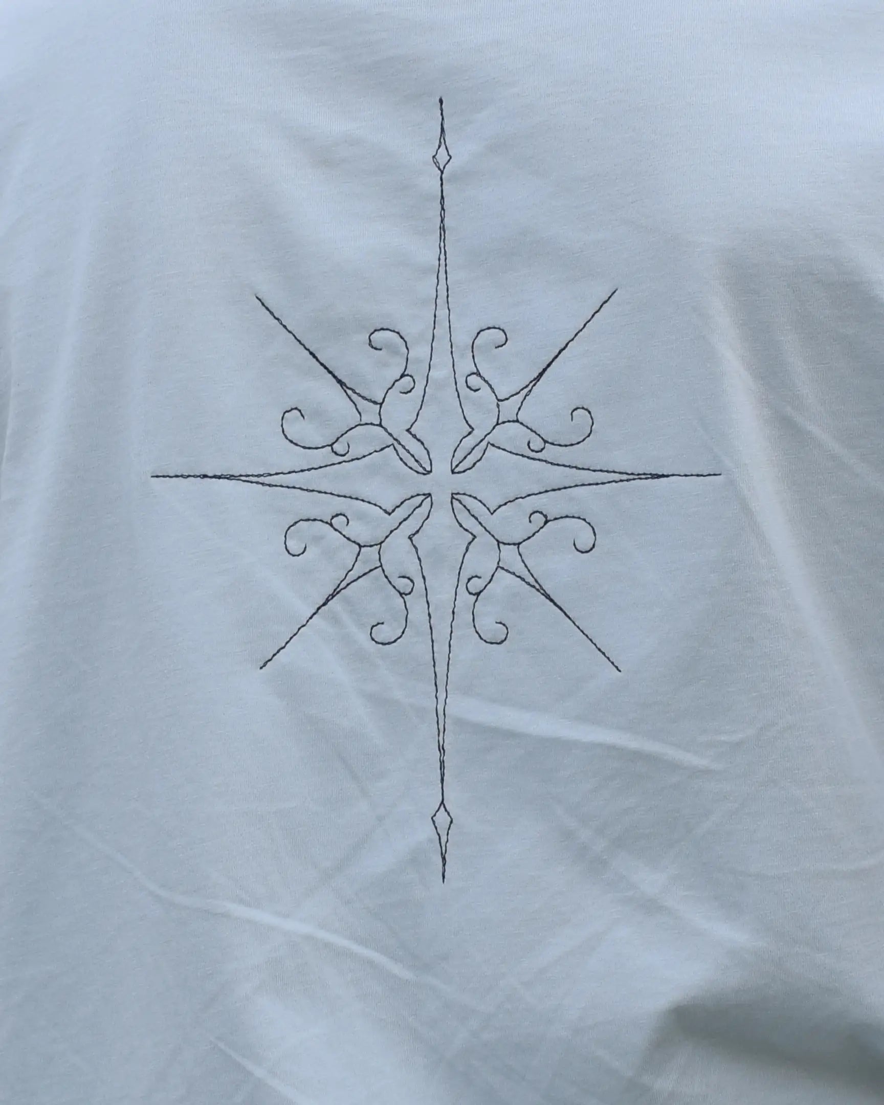 star embroidery tshirt compass design close up back