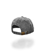 A washed charcoal gray baseball cap shown from the back, featuring a curved strap and metal slider, set against a plain white background with a soft shadow below.