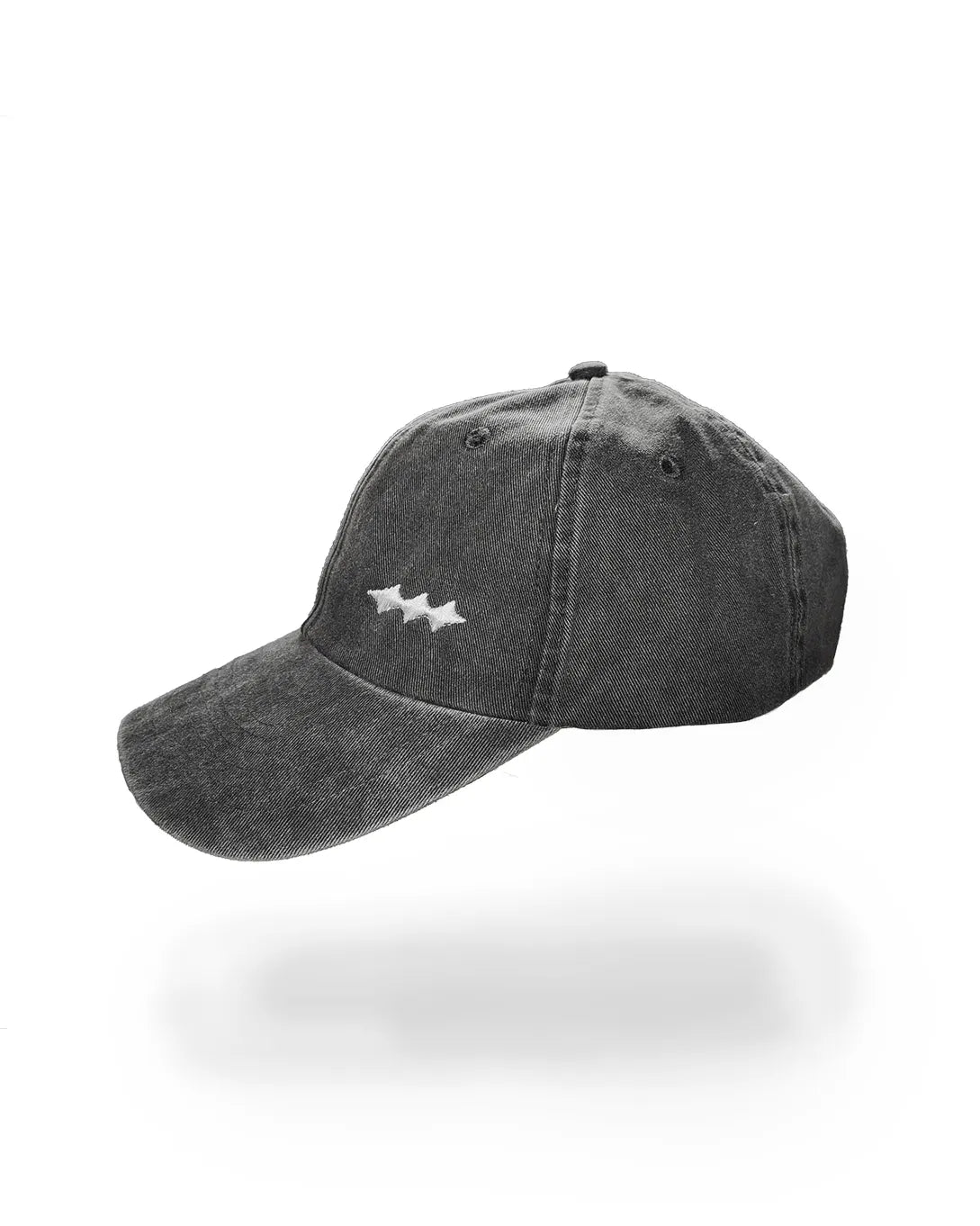A dark gray washed cotton baseball cap with a small white embroidered logo on the front, shown against a plain white background with a soft shadow underneath.